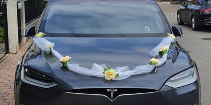 Hochzeitsauto-Vermietung - Marke: Tesla - Unser Tesla Model X aus 2020 in Spacegray mit dezentem Hochzeitsschmuck - Tesla Model X mit einzigartigen Flügeltüren in Spacegry 